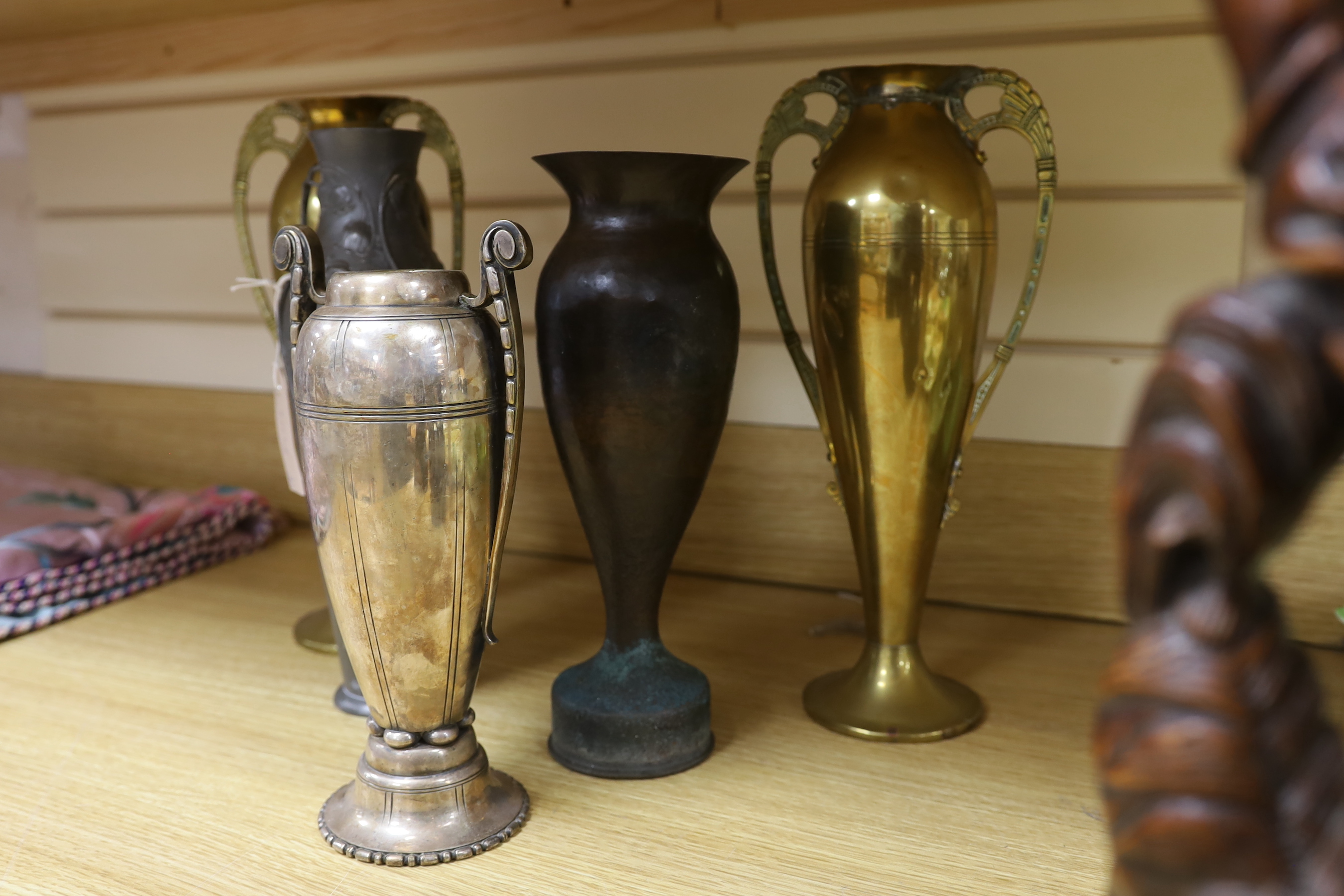 A Kayserzinn Art Nouveau pewter vase, a pair of brass vases, a plated vase and trench art vase